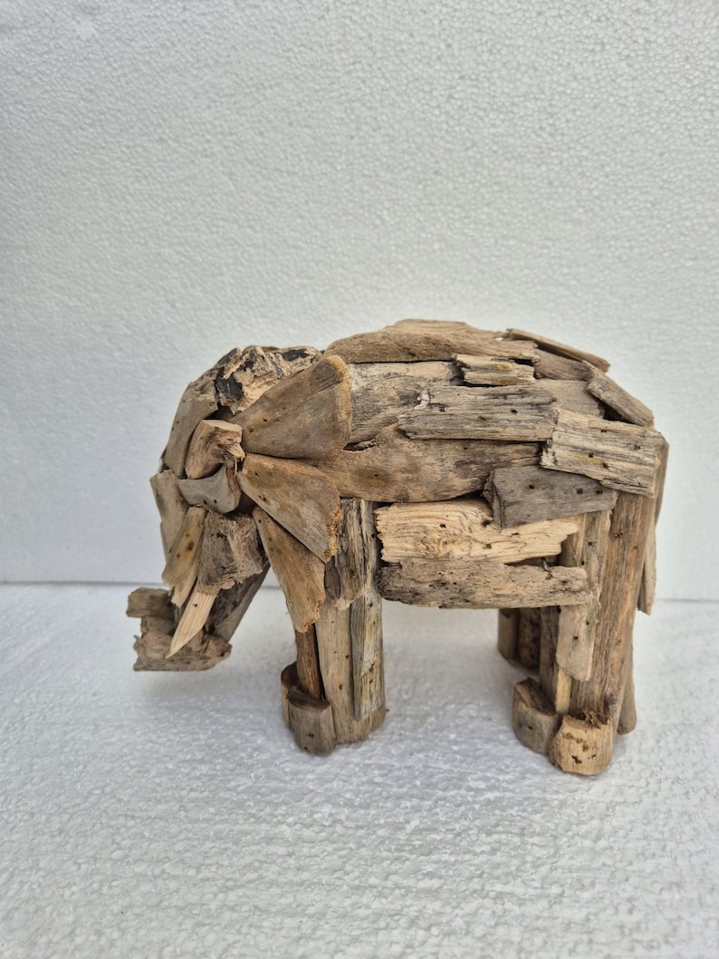 Pu&ograve; includere: Una scultura di elefante in legno fatta a mano. L'elefante &egrave; costruito con piccoli pezzi di legno di deriva, mostrando un aspetto naturale e invecchiato. La scultura ha quattro robuste zampe e una proboscide dettagliata, ideale per l'arredamento della casa.