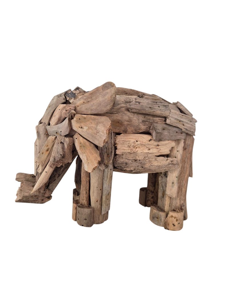 Pu&ograve; includere: Scultura di elefante in legno di deriva. La scultura &egrave; realizzata con vari pezzi di legno di colore naturale, con una proboscide, orecchie e quattro zampe. L'elefante &egrave; posto su uno sfondo bianco.
