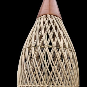 May include: A woven wicker lampshade with a brown leather top. The lampshade is shaped like a teardrop and has a diamond pattern.