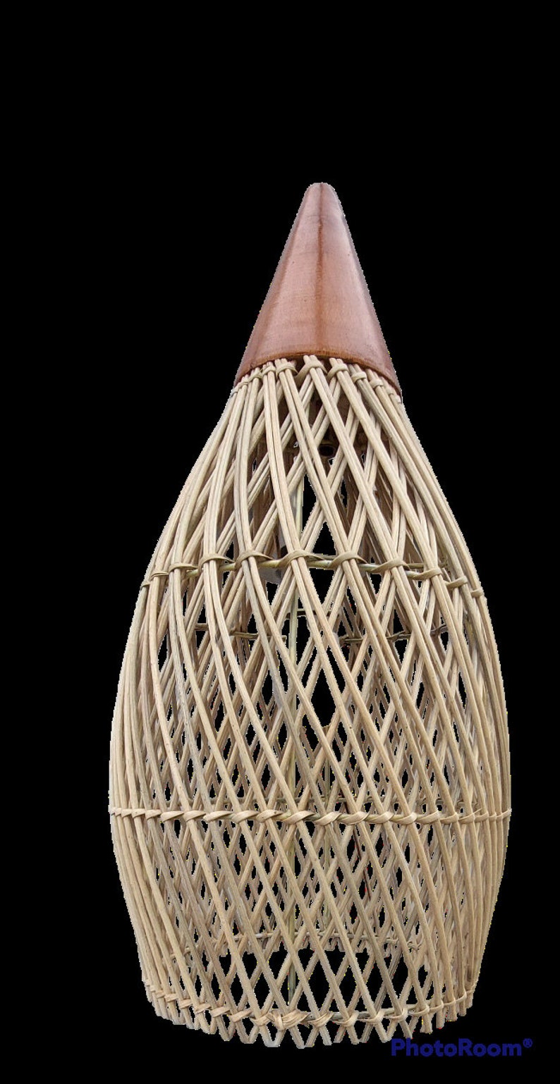 May include: A woven wicker lampshade with a brown leather top. The lampshade is shaped like a teardrop and has a diamond pattern.