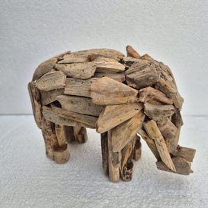 Pu&ograve; includere: Una scultura di elefante in legno di deriva fatta a mano. L'elefante &egrave; costruito con piccoli pezzi di legno, mostrando un'estetica naturale e rustica. Ha quattro zampe, una proboscide e orecchie. Un oggetto decorativo unico.