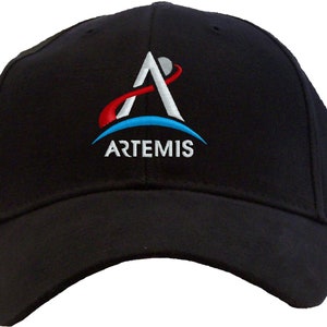 May include: Black baseball cap with an embroidered white and blue Artemis logo. The logo features a stylized letter A with a red and blue orbit around it.
