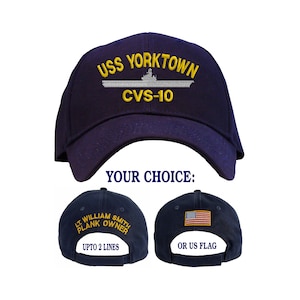 May include: A navy blue baseball cap with the text "USS YORKTOWN CVS-10" embroidered on the front. The back of the cap has an option for either a personalized embroidered name or the American flag.