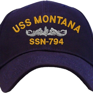 May include: A navy blue baseball cap with the text "USS MONTANA SSN-794" embroidered in gold and a silver submarine emblem.