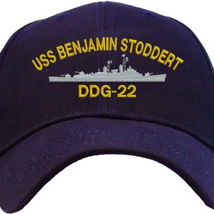 May include: A navy blue baseball cap with an embroidered image of the USS Benjamin Stoddert DDG-22.