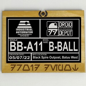 Puede incluir: Placa de madera con un dise&ntilde;o en blanco y negro. La placa presenta el texto "INDUSTRIAL AUTOMATON ASTROMECH DROIDS", "DROID DEPOT", "BB-A11 B-BALL" y "Black Spire Outpost, Batuu West". La fecha de creaci&oacute;n es 05/07/22.