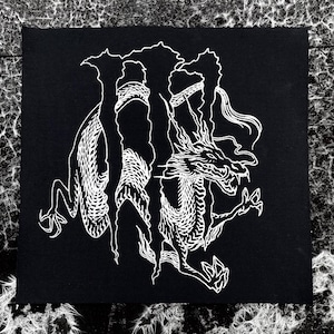 May include: A black fabric patch featuring a white screen-printed graphic of a stylized dragon intertwined with a large, jagged letter M. The dragon has detailed scales, sharp claws, and an open mouth, rendered in a high-contrast, bold line art style.