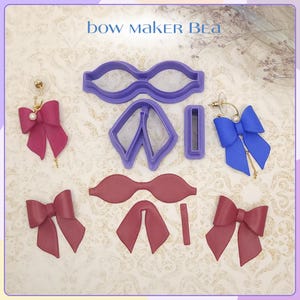 May include: The image showcases bow-shaped earrings in pink and blue, alongside purple bow-making cutters. The earrings feature pearl and chain accents. The text "bow maker Bea" is visible at the top of the image.