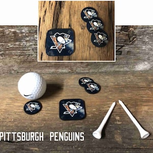 May include: Set of six black and gold Pittsburgh Penguins coasters with a golf ball and two white golf tees. The coasters feature a penguin logo with the team's name.