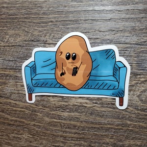May include: A cartoon potato with a surprised expression sits on a blue sofa holding a remote control. The sofa has a white outline and is on a wood background.