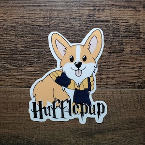 May include: A cartoon illustration of a corgi wearing a yellow and black scarf with the text "Hufflepup" underneath.