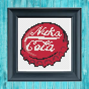 May include: A red and white Coca-Cola bottle cap cross-stitch pattern. The pattern is in a black frame.