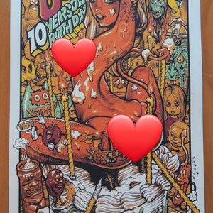 May include: A colorful illustration of a woman with a tattoo on her arm, surrounded by cartoon characters and candles. The woman is sitting on a cake with the words "Happy Birthday" written on it. The illustration is in a cartoon style and has a whimsical feel. The text "Junk Blues 10 Years of Birthday" is written in a bold font at the top of the illustration.