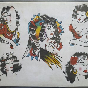 Op de afbeelding: Een tattoo flash sheet met vijf illustraties van figuren met donker haar. De centrale afbeelding toont een persoon met een kleurrijke papegaai, terwijl de andere portretten tonen met bloemaccenten, een hoed en rode lippen in een gedurfde stijl.