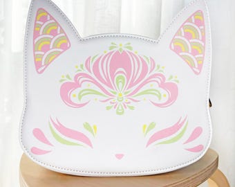 May include: White faux leather purse shaped like a cat's face with pink and green floral designs.