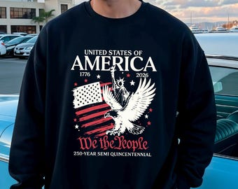 May include: Black sweatshirt with a graphic design featuring the American flag, an eagle, and the text "United States of America 1776-2026" and "We the People 250-Year Semi Quincentennial".