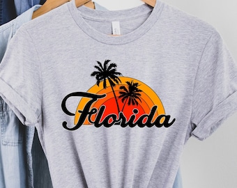 May include: Grey t-shirt with a retro sunset graphic and the text "Florida" in a black script font.