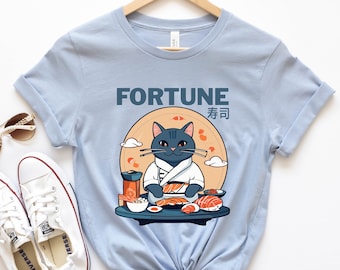May include: Light blue t-shirt featuring a graphic of a black cat wearing a white robe and holding a plate of sushi. The text "FORTUNE" and the Japanese characters for "fortune" are printed on the shirt.