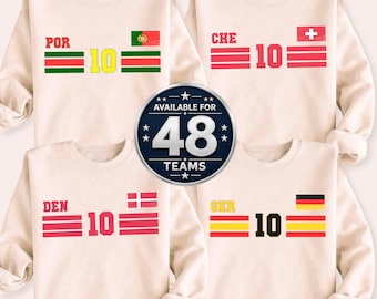 May include: Cream-colored sweatshirts with country flag designs. Each sweatshirt features a team abbreviation, the number "10", and a flag graphic. A central graphic states "AVAILABLE FOR 48 TEAMS".