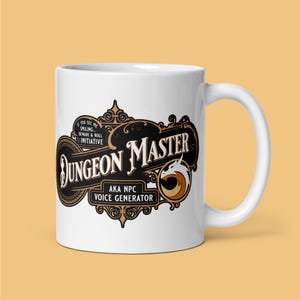 Peut inclure: Une tasse en céramique blanche avec un motif noir et or qui dit "Dungeon Master AKA NPC Voice Generator". Le motif comprend un dragon et des volutes ornées.