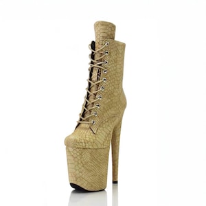 May include: Beige snakeskin-patterned ankle boots with a high platform and stiletto heel. The boots have a lace-up front and a pointed toe.