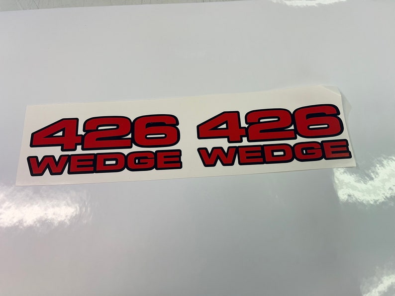 以下が含まれることがあります： 「426 Wedge」というテキストが書かれた、赤と黒のビニール製ステッカー2枚です。