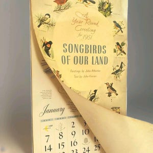 May include: Vintage 1951 calendar titled "Songbirds of Our Land" with illustrations of various birds. The calendar features the month of January, with dates visible. The cover has the text "A Year Round Greeting for 1951".