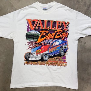 May include: White t-shirt featuring a colorful graphic of a race car with the text "Valley Bad Boys" and "Lebanon Valley Speedway". The design includes flames, a mountain scene, and the phrase "Feared By Some, Respected By All".