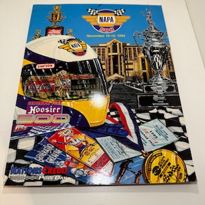Può includere: Una copertina di programma colorata per la gara NAPA 500, tenutasi all'Atlanta Motor Speedway nel novembre 1995. La copertina presenta un casco da corsa giallo e blu, una lattina di Coca-Cola e un trofeo. Il testo "NAPA 500" è in bella mostra nella parte superiore centrale dell'immagine.