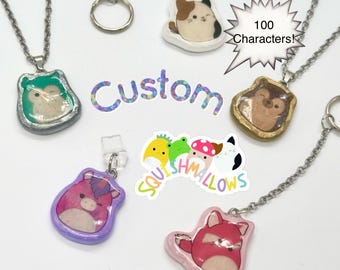 May include: A collection of handmade resin pendants and keychains featuring cartoon animal designs. The pendants are attached to silver-colored chains and key rings. The word "Custom" is also visible.