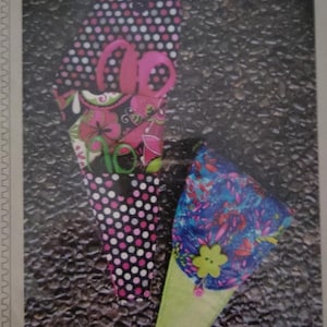 May include: A sewing pattern for a three pocket scissor case. The pattern features a black and white polka dot fabric, a floral fabric with pink and green accents, and a blue and pink floral fabric. The pattern is titled "SWD 269 - a three pocket scissor case."