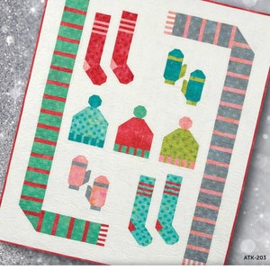 May include: A quilt pattern featuring a winter theme with a variety of winter accessories, including scarves, mittens, hats, and socks. The pattern is called "Frosty Fun!" and is from Atkinson Designs.