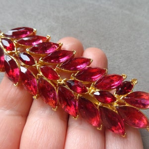 Large gold-tone floral brooch with fuchsia and red navette rhinestones