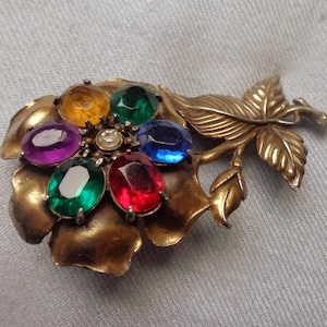 Grande broche en métal doré avec une fleur de rose avec des pétales en plastique et un strass