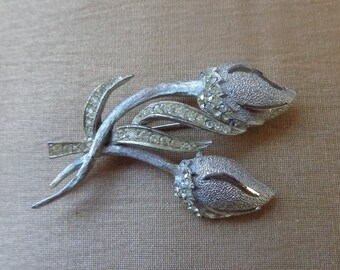 BSK silver tone floral brooch with clear rhinestones