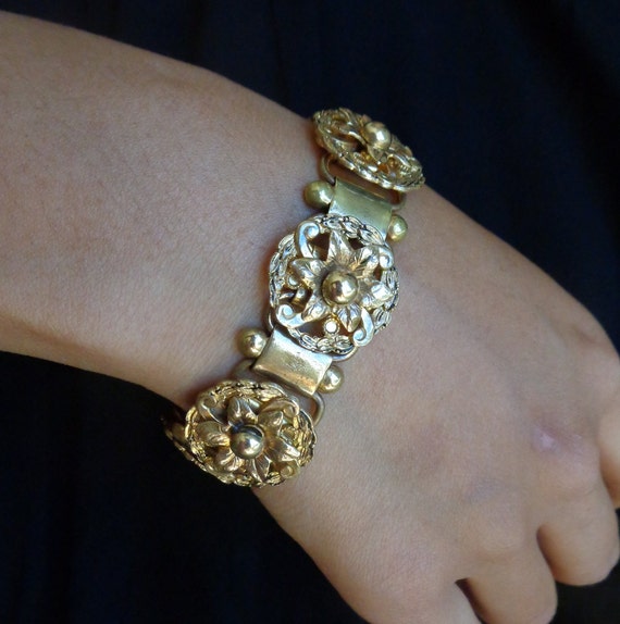Gold tone all metal ornamental floral bracelet