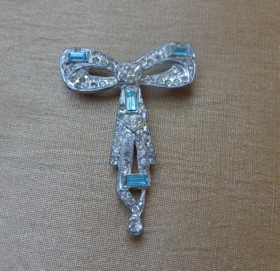 Pot metal bow brooch with blue and clear rhinesto… - image 1
