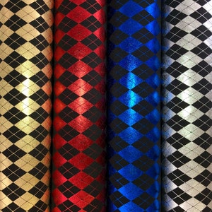 May include: Four rolls of fabric with a black and white diamond pattern. The fabric rolls are gold, red, blue, and silver.