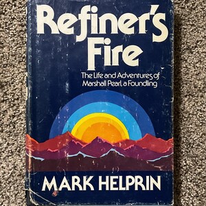 May include: A vintage hardcover book titled "Refiner's Fire" by Mark Helprin. The cover is dark blue with white lettering and a colorful illustration of a sunset over mountains. The book's subtitle is "The Life and Adventures of Marshall Pearl, a Foundling."