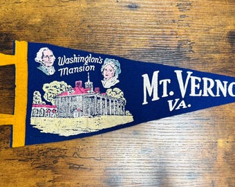 May include: A blue pennant with yellow trim and ties. The pennant features an illustration of Washington's Mansion, portraits of George and Martha Washington, and the text "Mt. Vernon VA."