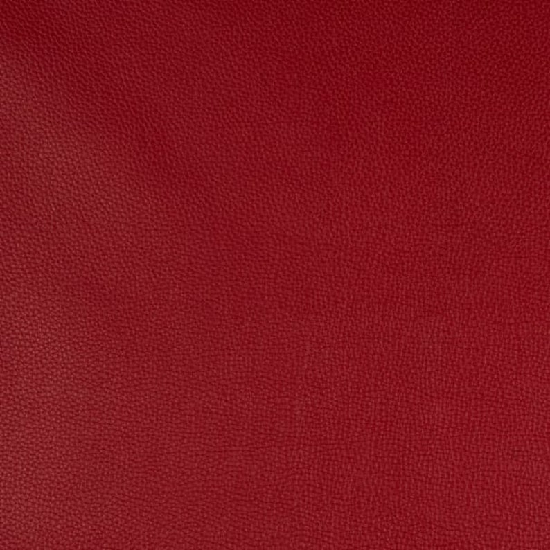 K&ouml;nnte beinhalten: Nahaufnahme eines tief roten, strukturierten Stoffes. Der Stoff hat eine subtile, genarbte Textur.
