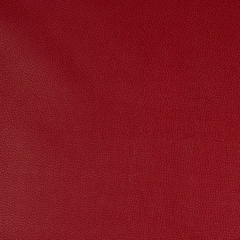 May include: A close-up of a deep red textured fabric. The fabric has a pebbled surface and a rich, solid color.