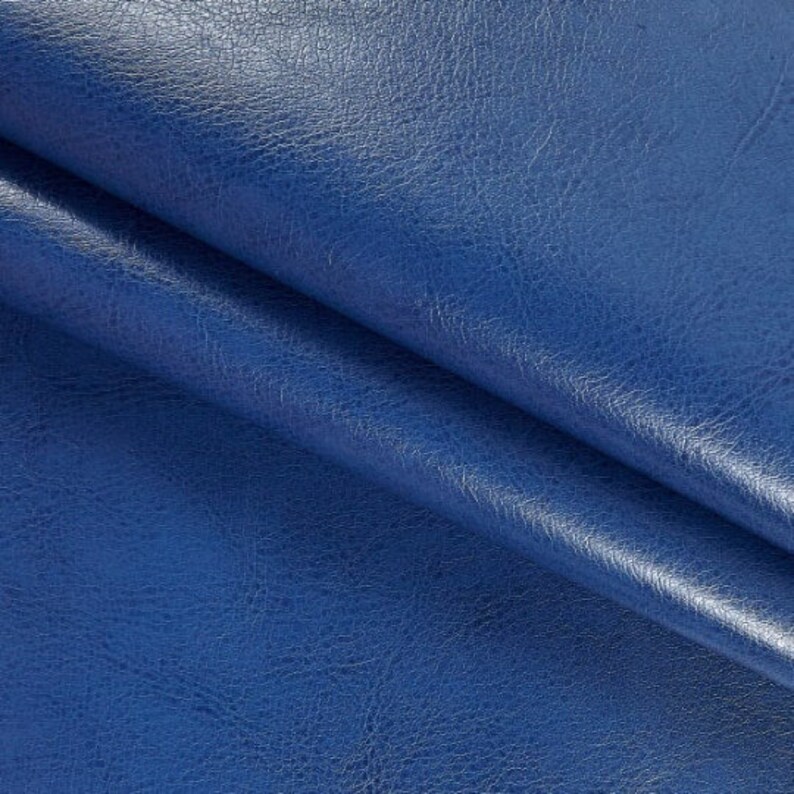 K&ouml;nnte beinhalten: Nahaufnahme eines blauen Kunstleders mit strukturierter Oberfl&auml;che.
