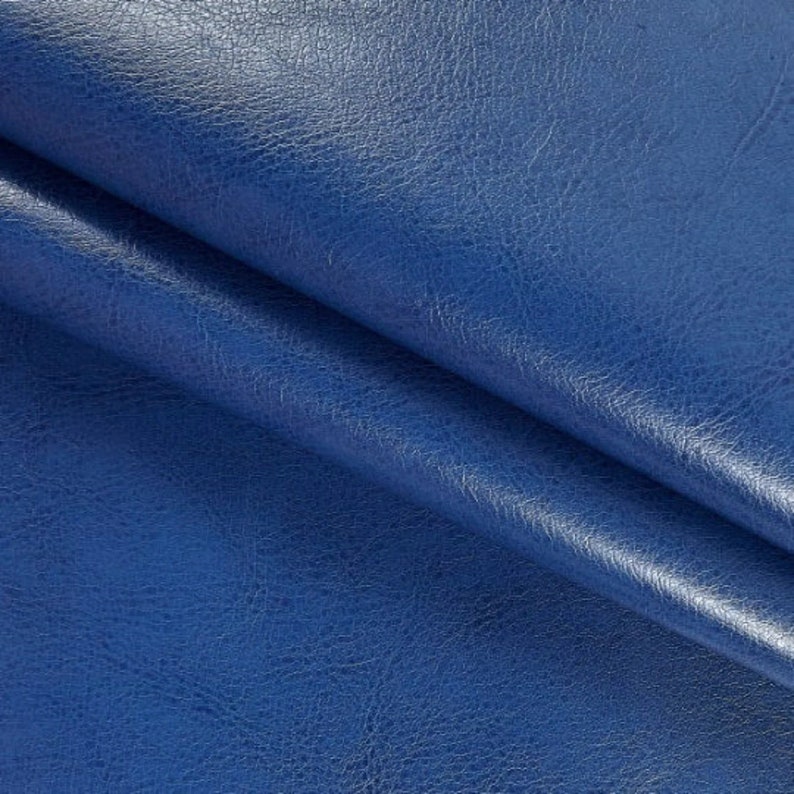 May include: Close-up of a blue faux leather fabric with a textured surface.