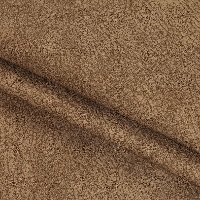 May include: Close-up of a brown faux leather fabric with a textured surface.