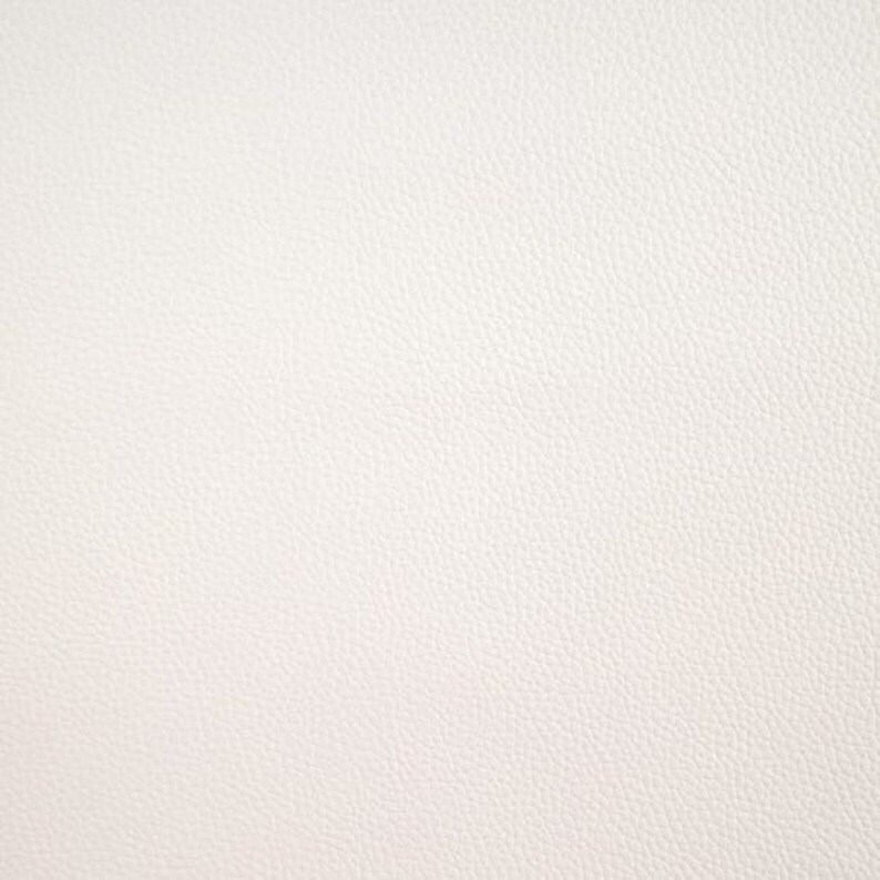 May include: A close-up of a white textured surface. The surface has a subtle, grainy texture.
