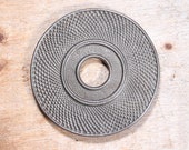 Round shaped Cast iron trivet with hole in middle.