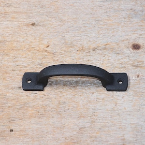 Peut inclure: Poignée de porte en métal noir avec une forme arrondie et deux trous de vis.