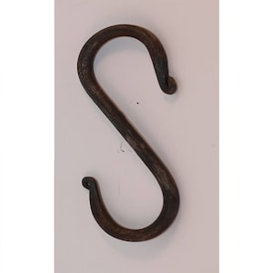 Peut inclure: Un crochet en S artisanal en métal brun foncé. Le crochet est en fer forgé épais avec une surface texturée. La conception en forme de S présente des extrémités arrondies, parfaites pour suspendre des objets. Le crochet est présenté sur fond blanc.