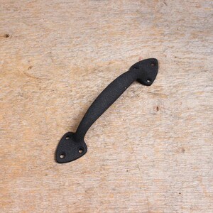 May include: Black metal door handle with a pointed design. The handle is about 6 inches long.